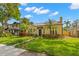 Quaint yellow home showcasing mature trees, a manicured lawn, and unique landscaping at 646 16Th Ne Ave, St Petersburg, FL 33704