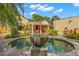 Backyard features an in-ground pool, fountain, lush landscaping, and covered patio seating at 646 16Th Ne Ave, St Petersburg, FL 33704