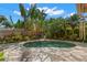 Beautiful in-ground pool surrounded by lush tropical landscaping and a stone patio area at 646 16Th Ne Ave, St Petersburg, FL 33704