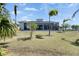 Large, grassy backyard with palm trees and screened-in patio at 706 Manns Harbor Dr, Apollo Beach, FL 33572