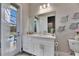 Bright bathroom with door to outdoor living, white cabinets, and quartz countertop at 706 Manns Harbor Dr, Apollo Beach, FL 33572