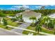 Exterior view of the house, showcasing the three-car garage, landscaping, and paver driveway at 706 Manns Harbor Dr, Apollo Beach, FL 33572
