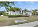 Well-maintained home exterior with lush landscaping, palm trees, and a neatly manicured lawn at 706 Manns Harbor Dr, Apollo Beach, FL 33572