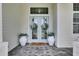 Inviting front door with glass panels, flanked by potted plants and a 'hello' door mat at 706 Manns Harbor Dr, Apollo Beach, FL 33572