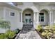 Elegant front entrance with double doors, decorative wreaths, and manicured landscaping creates a welcoming curb appeal at 706 Manns Harbor Dr, Apollo Beach, FL 33572