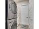 Modern laundry room featuring stackable washer and dryer, white cabinets, and tiled floor at 706 Manns Harbor Dr, Apollo Beach, FL 33572