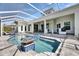 Stunning screened pool area with spa, covered lanai, outdoor kitchen, and water feature with stone accents at 706 Manns Harbor Dr, Apollo Beach, FL 33572
