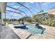 Inviting screened pool with blue tile spa, water feature, and serene backyard views with a beautiful landscape at 706 Manns Harbor Dr, Apollo Beach, FL 33572