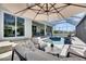 Outdoor living space with patio seating overlooking a sparkling pool and spa in a screened enclosure at 706 Manns Harbor Dr, Apollo Beach, FL 33572