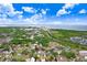An aerial view of the neighborhood showing a house with a vibrant green lawn and mature trees at 7113 S Mascotte St, Tampa, FL 33616