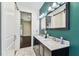 Well-lit bathroom featuring dual sinks, modern fixtures, and an attached living space at 7113 S Mascotte St, Tampa, FL 33616