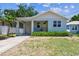 Charming blue bungalow with a covered porch, yellow front door, and an attached garage at 7113 S Mascotte St, Tampa, FL 33616
