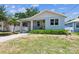 Charming blue bungalow with a covered porch, yellow front door, and an attached garage at 7113 S Mascotte St, Tampa, FL 33616