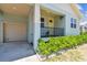 Charming front porch of this blue home featuring an attached garage and decorative landscaping at 7113 S Mascotte St, Tampa, FL 33616