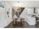 Bright kitchen with dining area, showcasing white cabinets, modern lighting, and dark wood-look floors at 7113 S Mascotte St, Tampa, FL 33616