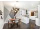 Bright kitchen with dining area, showcasing white cabinets, modern lighting, and dark wood-look floors at 7113 S Mascotte St, Tampa, FL 33616