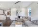 Cozy living room boasts a comfortable gray sectional, colorful artwork, and dark wood-look floors at 7113 S Mascotte St, Tampa, FL 33616