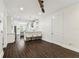 Open-concept living room and kitchen with dark wood floors and white cabinets at 7113 S Mascotte St, Tampa, FL 33616