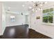 Open concept living space features modern light fixture, white cabinets, and dark wood-look floors at 7113 S Mascotte St, Tampa, FL 33616