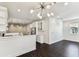 Open concept living space features modern light fixture, white cabinets, and dark wood-look floors at 7113 S Mascotte St, Tampa, FL 33616