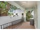 Cozy porch with a ceiling fan, outdoor space, a view of the neighboring property, and a black iron railing at 7113 S Mascotte St, Tampa, FL 33616