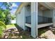 Charming side exterior featuring a covered porch with railing and a view of the landscaped yard and shed at 7113 S Mascotte St, Tampa, FL 33616