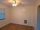 Clean bedroom featuring light-colored walls, wood-look flooring, a ceiling fan, and natural light from the window at 754 71St N Ave, St Petersburg, FL 33702