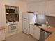 Kitchen with white appliances, wooden countertops, modern sink and mosaic backsplash at 754 71St N Ave, St Petersburg, FL 33702