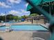 Community pool provides a refreshing escape with ample seating under the shaded umbrellas on a sunny day at 754 71St N Ave, St Petersburg, FL 33702