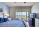 Serene bedroom with water views from the balcony and a cooling ceiling fan at 7872 Sailboat Key S Blvd # 404, South Pasadena, FL 33707