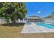 A spacious backyard features lush greenery, a patio, and a large shade tree, creating a serene outdoor retreat at 827 Virginia St, Dunedin, FL 34698