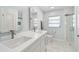Bright bathroom featuring a double sink vanity, modern fixtures, and a glass-enclosed shower at 827 Virginia St, Dunedin, FL 34698