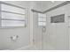 Shower with seamless glass door features stylish mosaic tile accents and built-in niche at 827 Virginia St, Dunedin, FL 34698