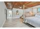 Spacious bedroom featuring a wooden ceiling, light-colored flooring, and a four-poster bed at 827 Virginia St, Dunedin, FL 34698