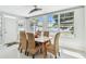 Bright dining room with four large windows, a modern light fixture, and seating for six at 827 Virginia St, Dunedin, FL 34698