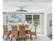 Bright dining room with four large windows, a modern light fixture, and seating for six at 827 Virginia St, Dunedin, FL 34698