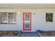 Close-up of the vibrant front door with brick entryway and manicured landscaping at 827 Virginia St, Dunedin, FL 34698