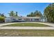 Single-story home boasts lush lawn, circular driveway, and vibrant front door at 827 Virginia St, Dunedin, FL 34698