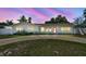 Charming single-story home with a well-manicured front yard, circular driveway, and a striking red front door at 827 Virginia St, Dunedin, FL 34698