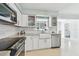 Bright kitchen with white cabinets, stainless appliances, subway tile backsplash, and granite countertops at 827 Virginia St, Dunedin, FL 34698