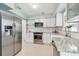 Modern kitchen with stainless steel appliances, white cabinets, and granite countertops at 827 Virginia St, Dunedin, FL 34698