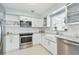 Bright kitchen with white cabinets, stainless appliances, subway tile backsplash, and granite countertops at 827 Virginia St, Dunedin, FL 34698