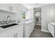Bright laundry room with modern washer and dryer, plus a utility sink with elegant countertops at 827 Virginia St, Dunedin, FL 34698