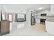 Open-concept living area featuring modern appliances, bright white walls, and a red front door at 827 Virginia St, Dunedin, FL 34698