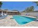 Large backyard pool area with pavers, lounge chairs, and privacy fencing at 827 Virginia St, Dunedin, FL 34698