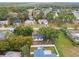Aerial shot showcasing a home with solar panels and fenced backyard in a leafy neighborhood with nearby homes and mature trees at 8512 Longboat Ln, Hudson, FL 34667