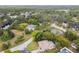 Aerial view captures a charming home near a tranquil pond, surrounded by lush greenery in a peaceful residential area at 8512 Longboat Ln, Hudson, FL 34667