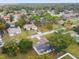 Aerial view of a single-story home with solar panels and a large yard, nestled in a serene, tree-lined neighborhood at 8512 Longboat Ln, Hudson, FL 34667