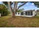 Spacious backyard features a mature tree and a screened patio at 8512 Longboat Ln, Hudson, FL 34667