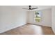 Light-filled bedroom boasts hardwood floors, a modern ceiling fan, and a large window at 8512 Longboat Ln, Hudson, FL 34667